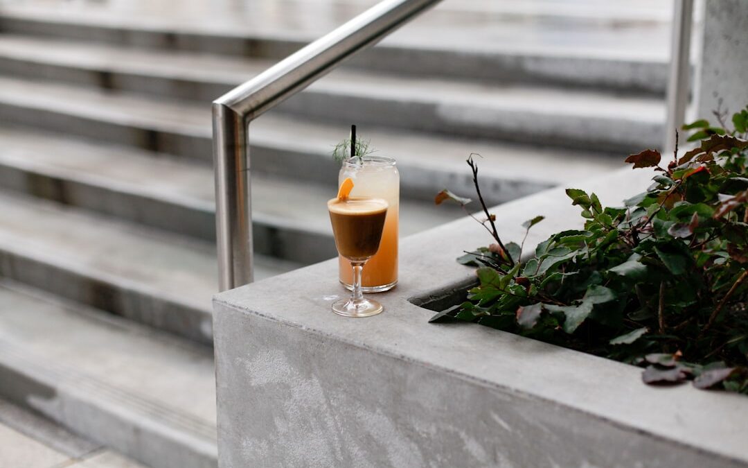 Espresso Martini and cocktail on a concrete ledge, surrounded by greenery, highlighting Mix Lounge's innovative beverage offerings.